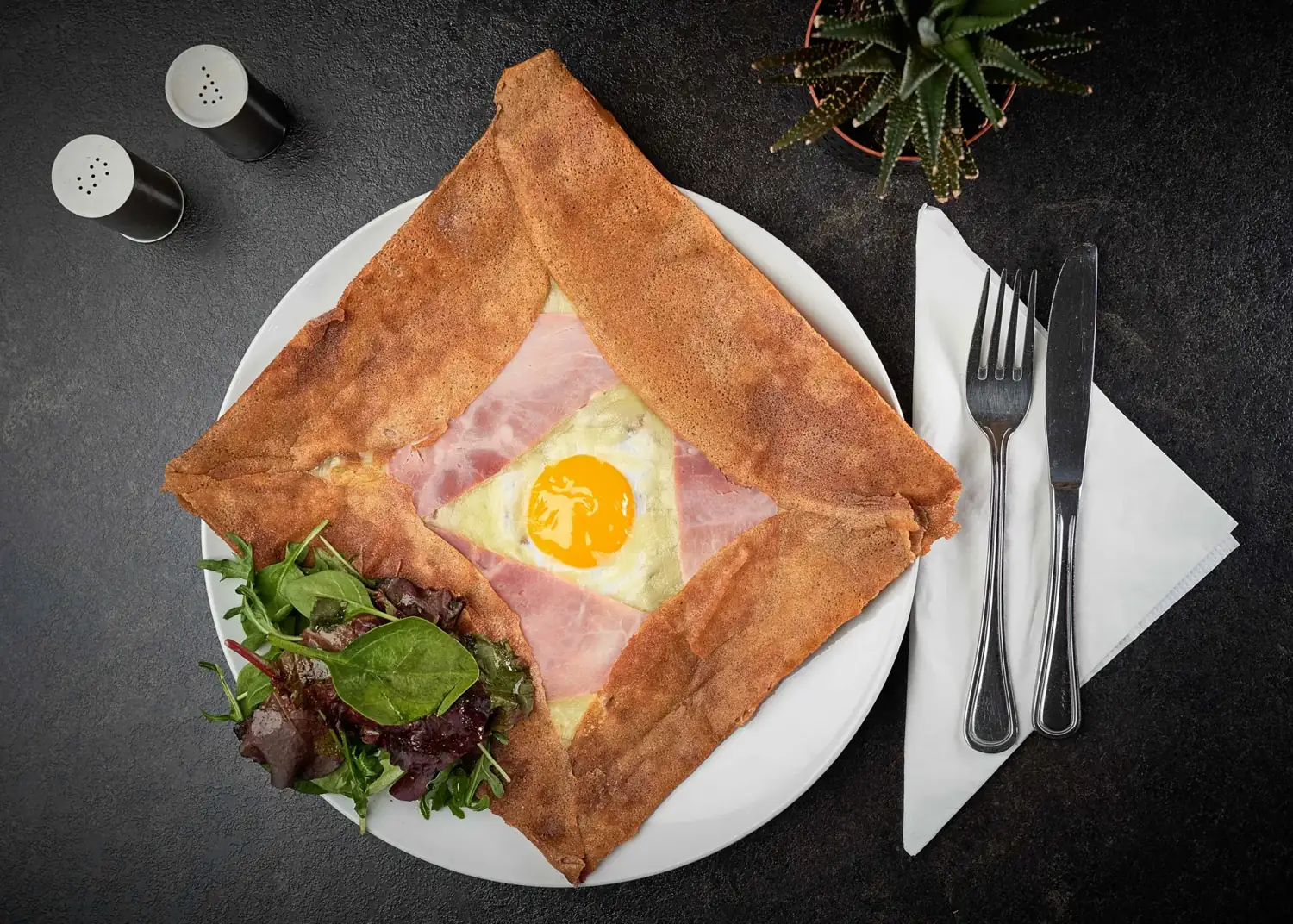 Galette complète pliée en carré, jambon, emmental et œuf, avec sa salade